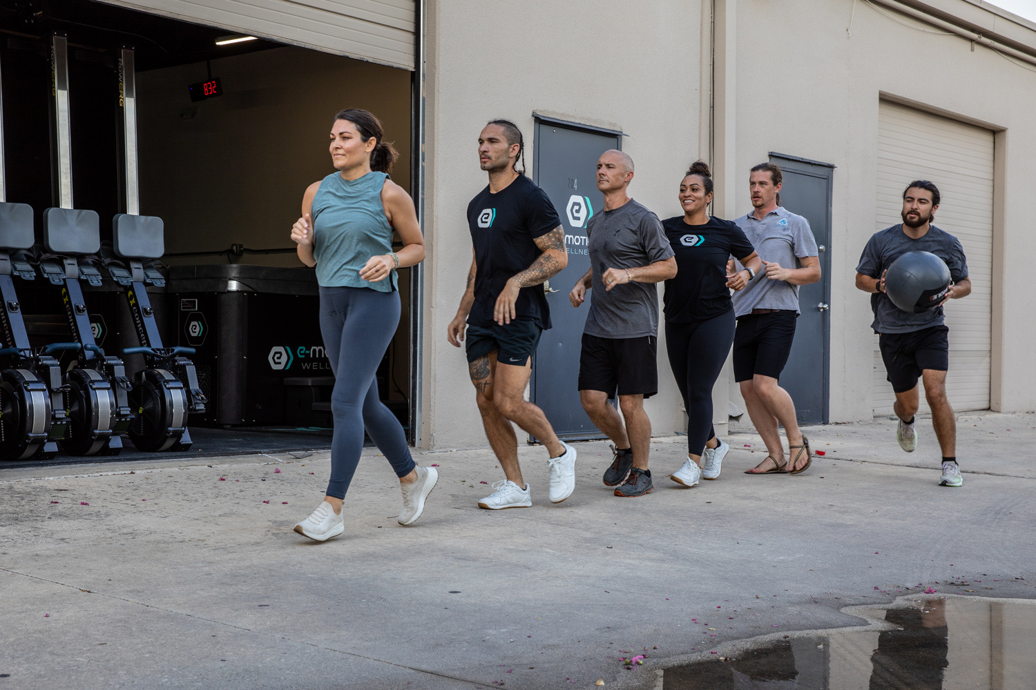Clients and staff running together outside the e-motion wellness® gym