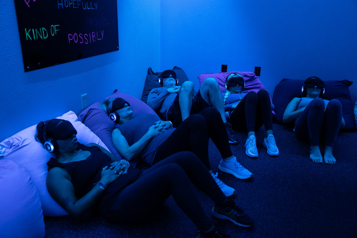 A guided relaxation session in the recovery room, clients in eye masks and headphones
